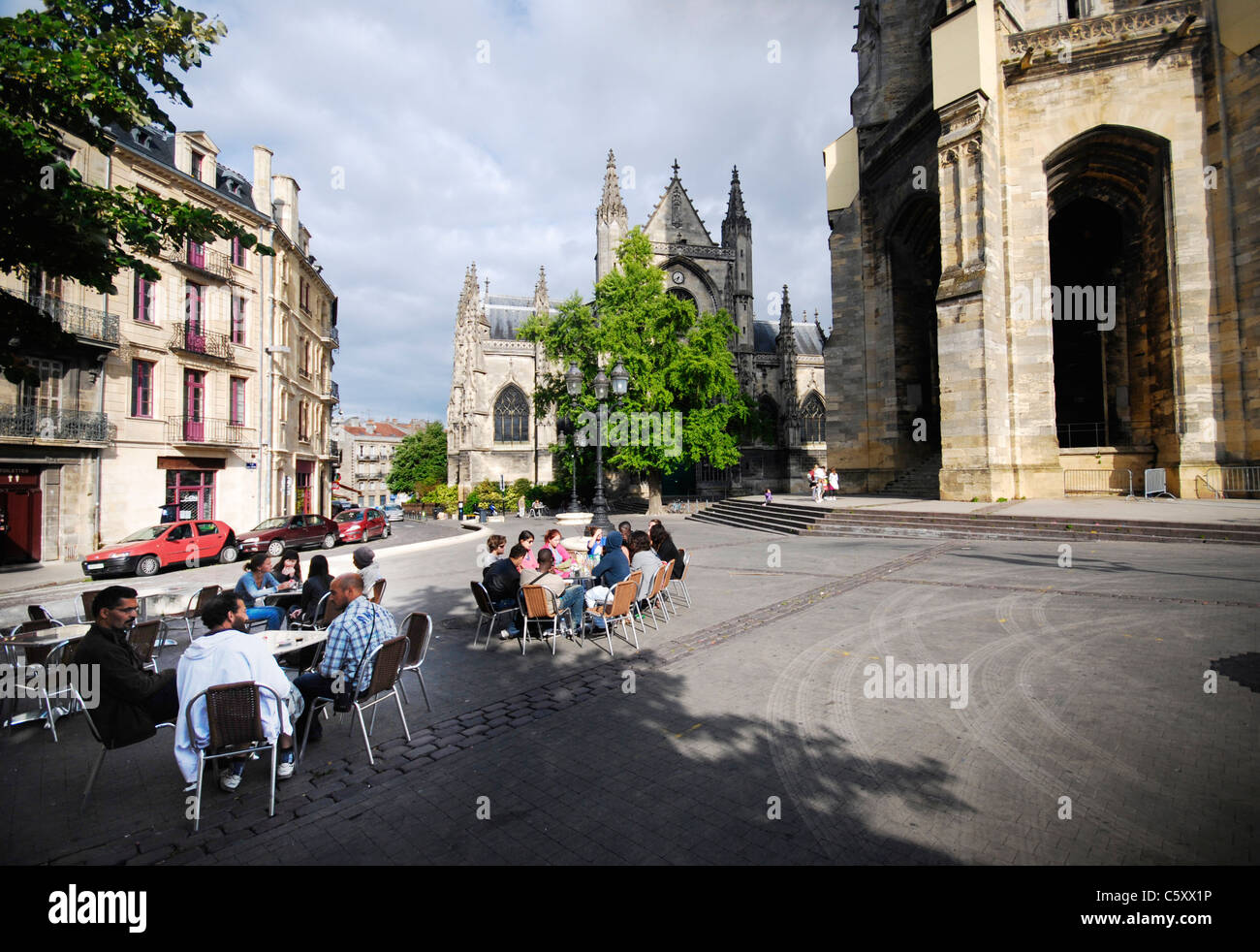 Les gens se détendre dans les restaurants sur place Meynard par la majestueuse église médiévale basilique Saint-Michel à Bordeaux, France. Banque D'Images