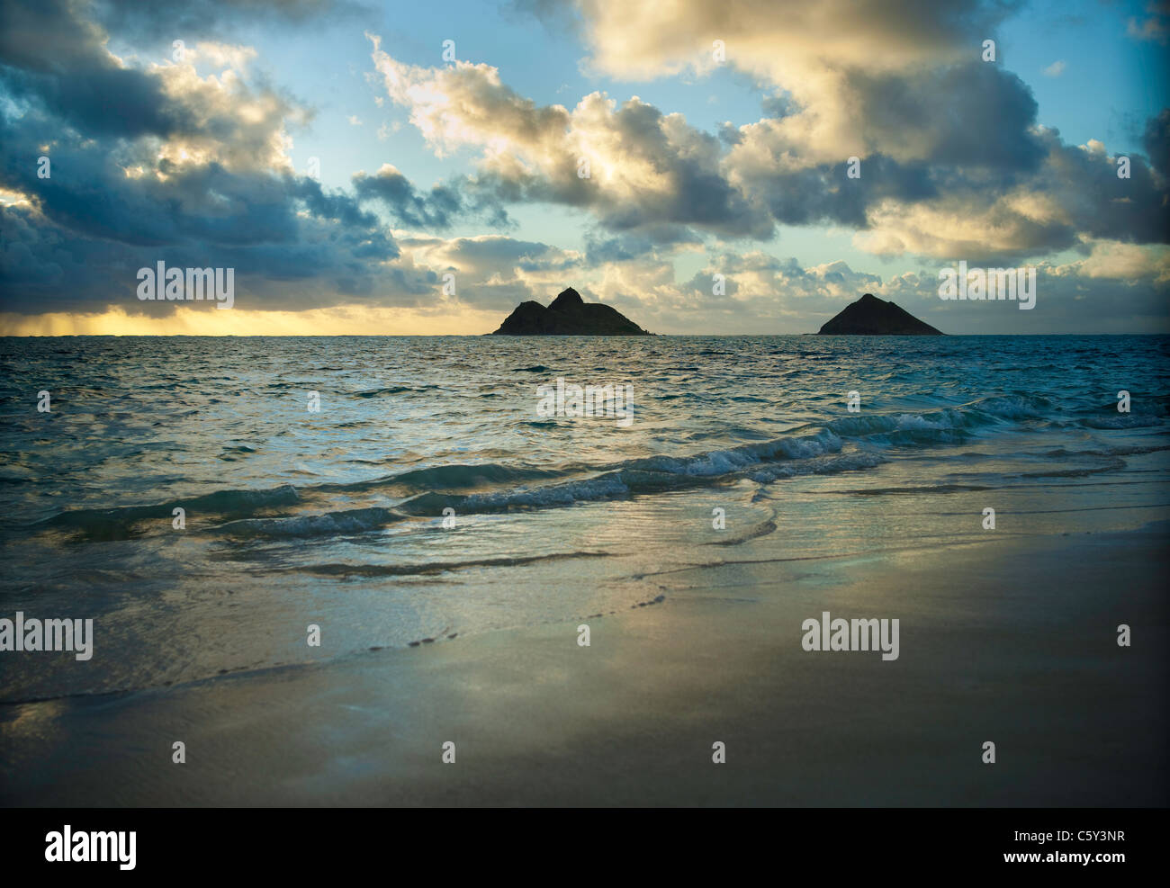 Lever du soleil à Lanikai Beach sur la côte d'Oahu au vent, Mokolua îles dans la distance. Banque D'Images