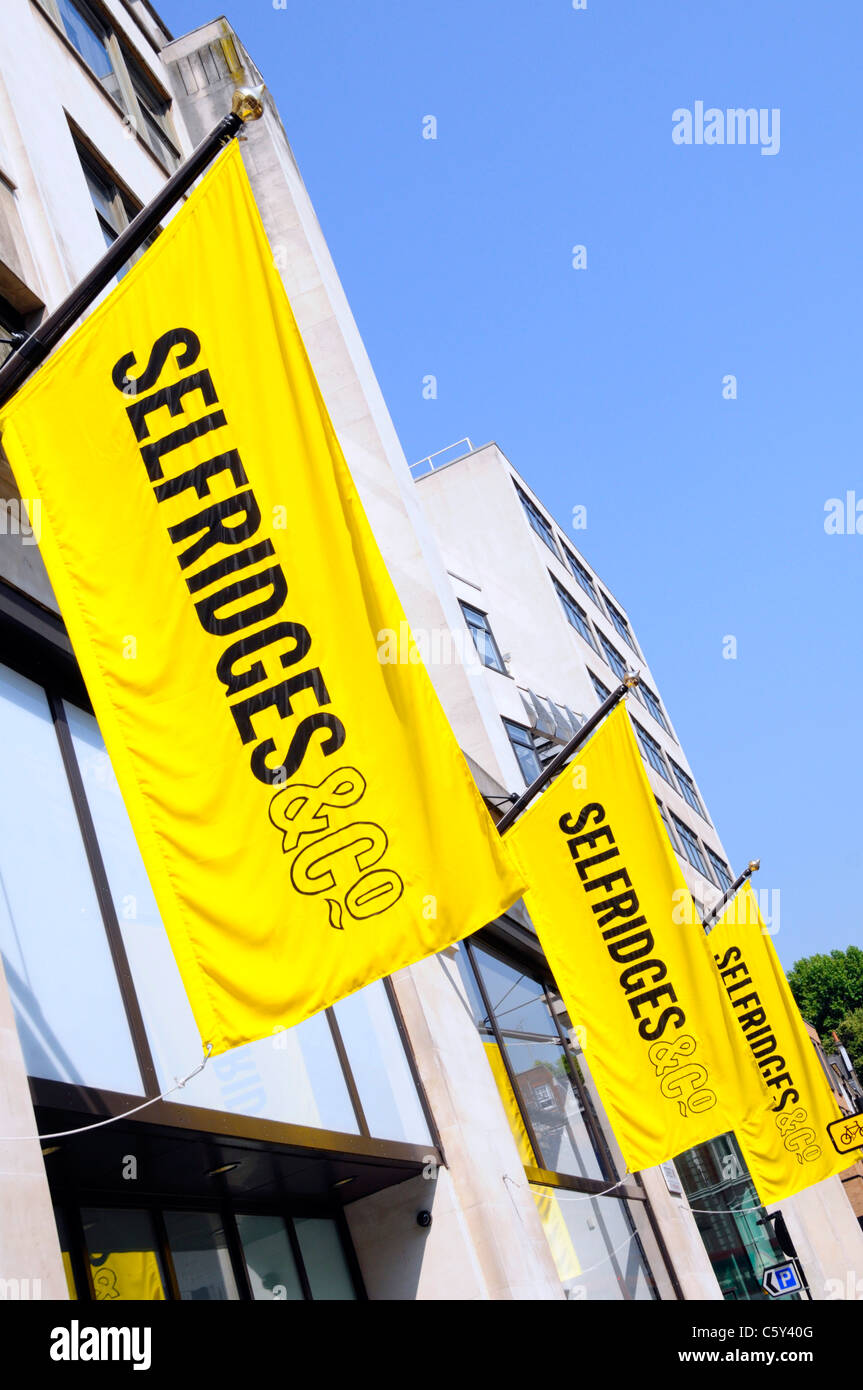 Selfridges & Co Retail Department Retail business shopping store emblématique logo jaune vif bannières bleu ciel soleil jour à West End Londres Angleterre Royaume-Uni Banque D'Images