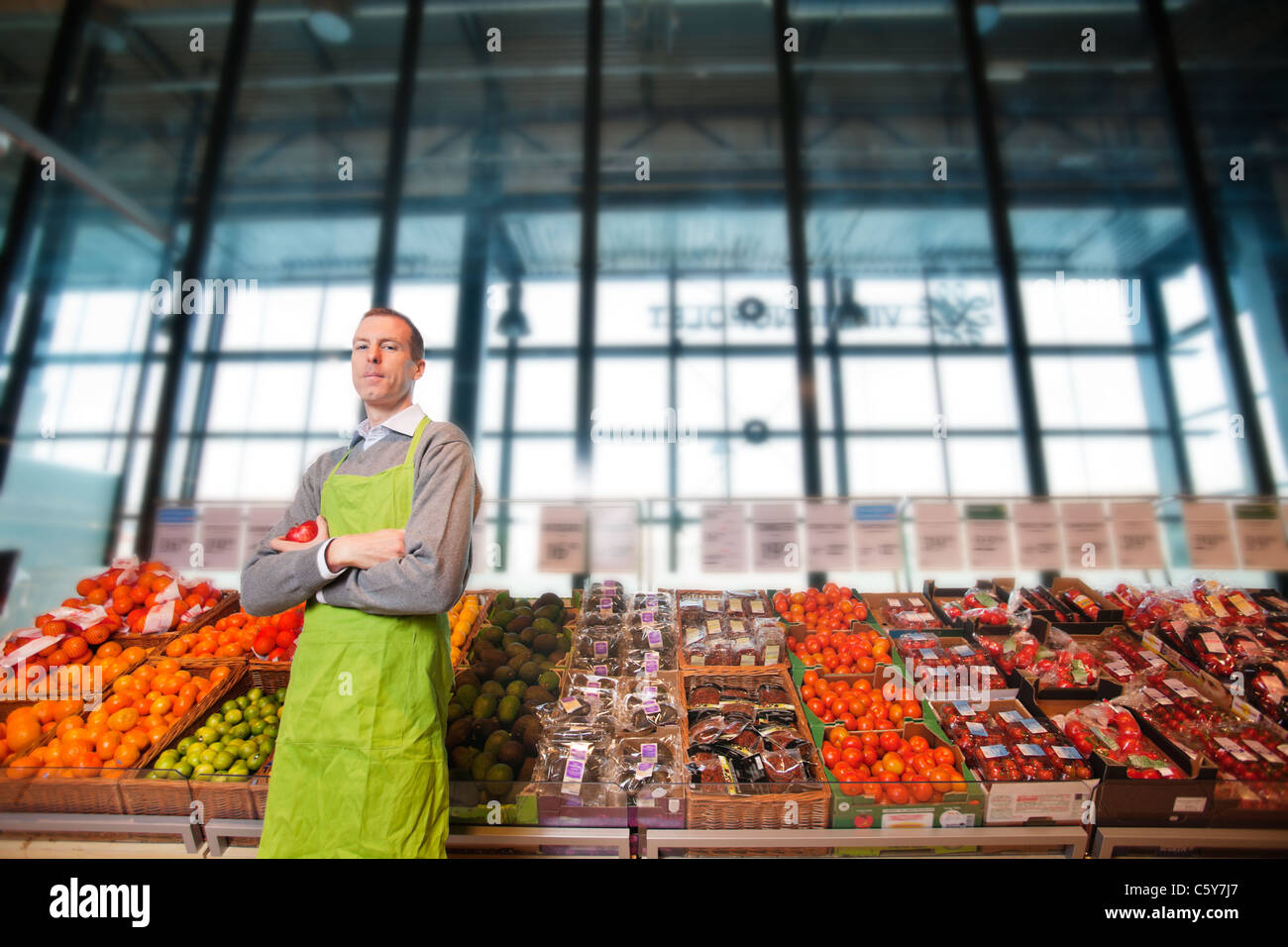 Portrait d'un magasin d'clkerk ou propriétaire en face d'un comptoir de légumes Banque D'Images