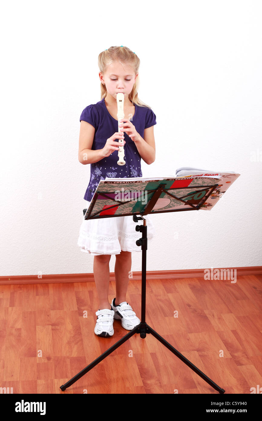 Cute girl jouant la flûte avec notes de musique Banque D'Images