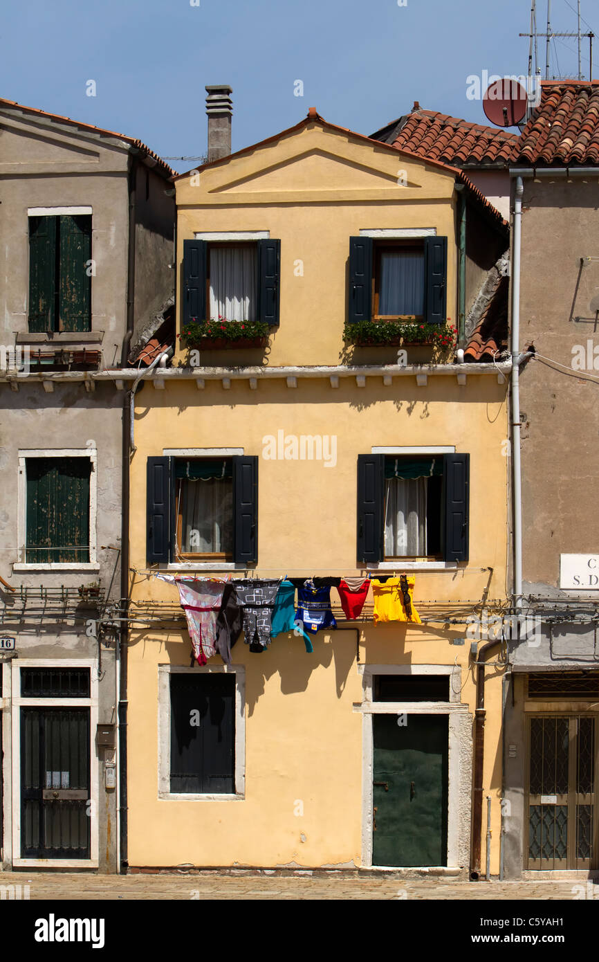 Maison à Venise, en Italie avec l'architecture ancienne et de blanchisserie étendus dehors les fenêtres, montrant comment les Italiens vivent. Banque D'Images