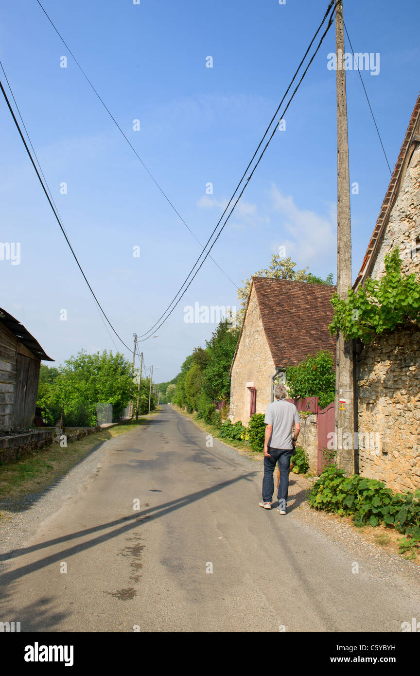L'homme est la marche dans un petit village français Banque D'Images