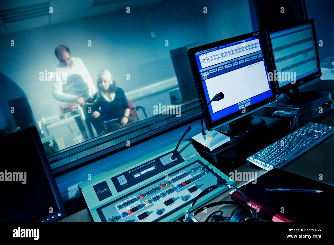 L'audiologie et de la surdité cabine de son laboratoire d'expérimentation avec des contrôles et des écrans d'ordinateur en premier plan l'objet portant des électrodes Banque D'Images