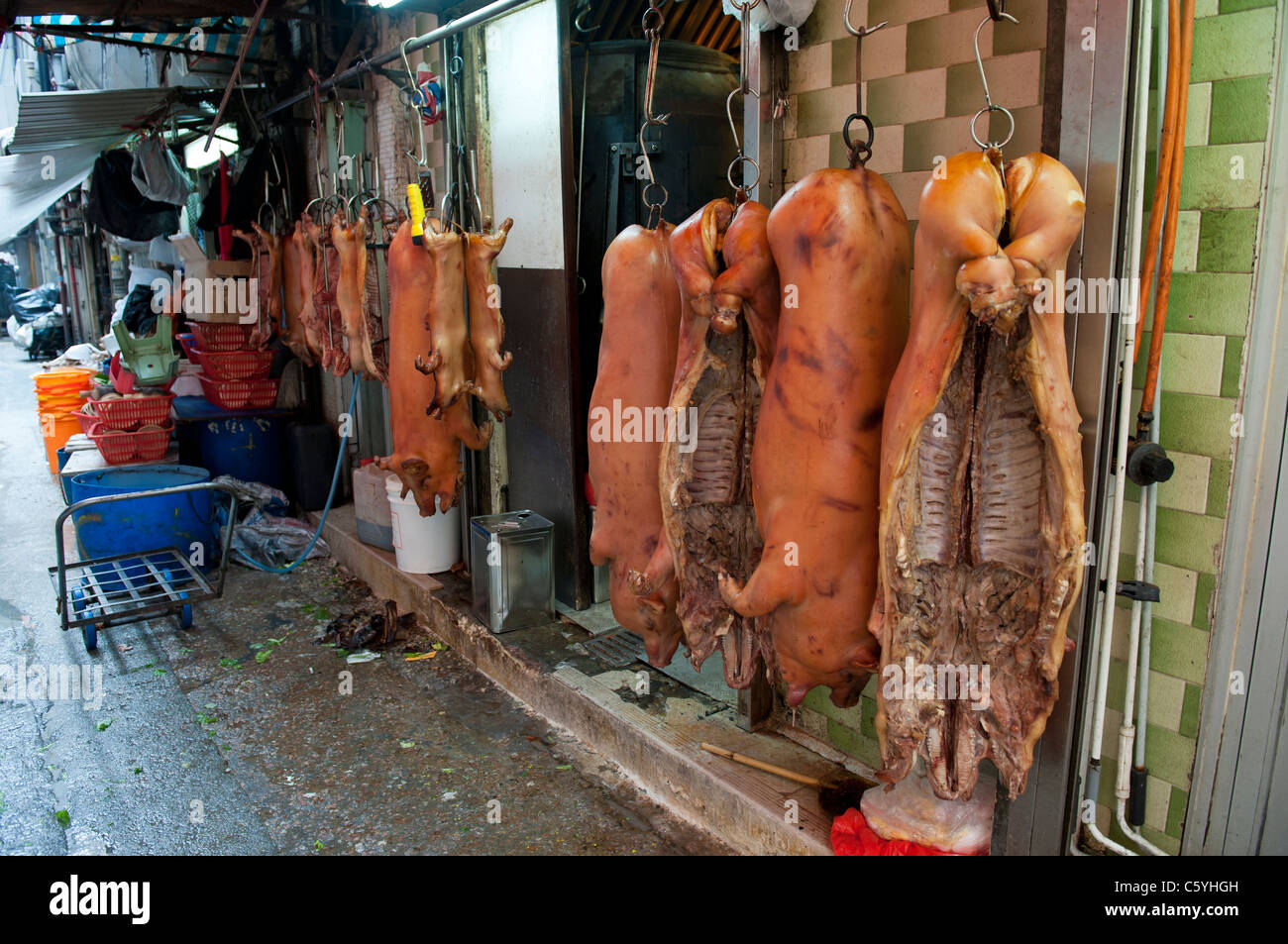 Des carcasses de porc séché au barbecue suspendu dans une ruelle à côté d'une boutique près de bouchers Tung Choi Street à Kowloon Banque D'Images