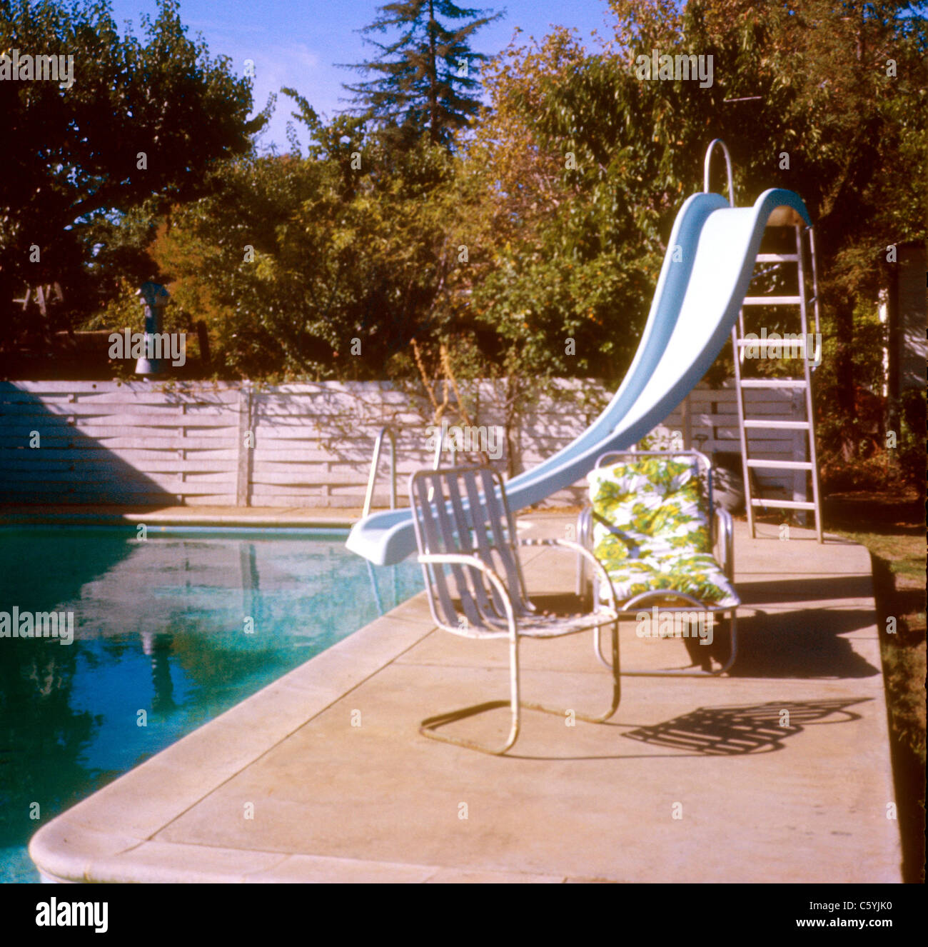 Arrière-cour creusée dans la piscine avec toboggan et 70 président 1977 1970 Meubles Décoration architecture lawn Banque D'Images