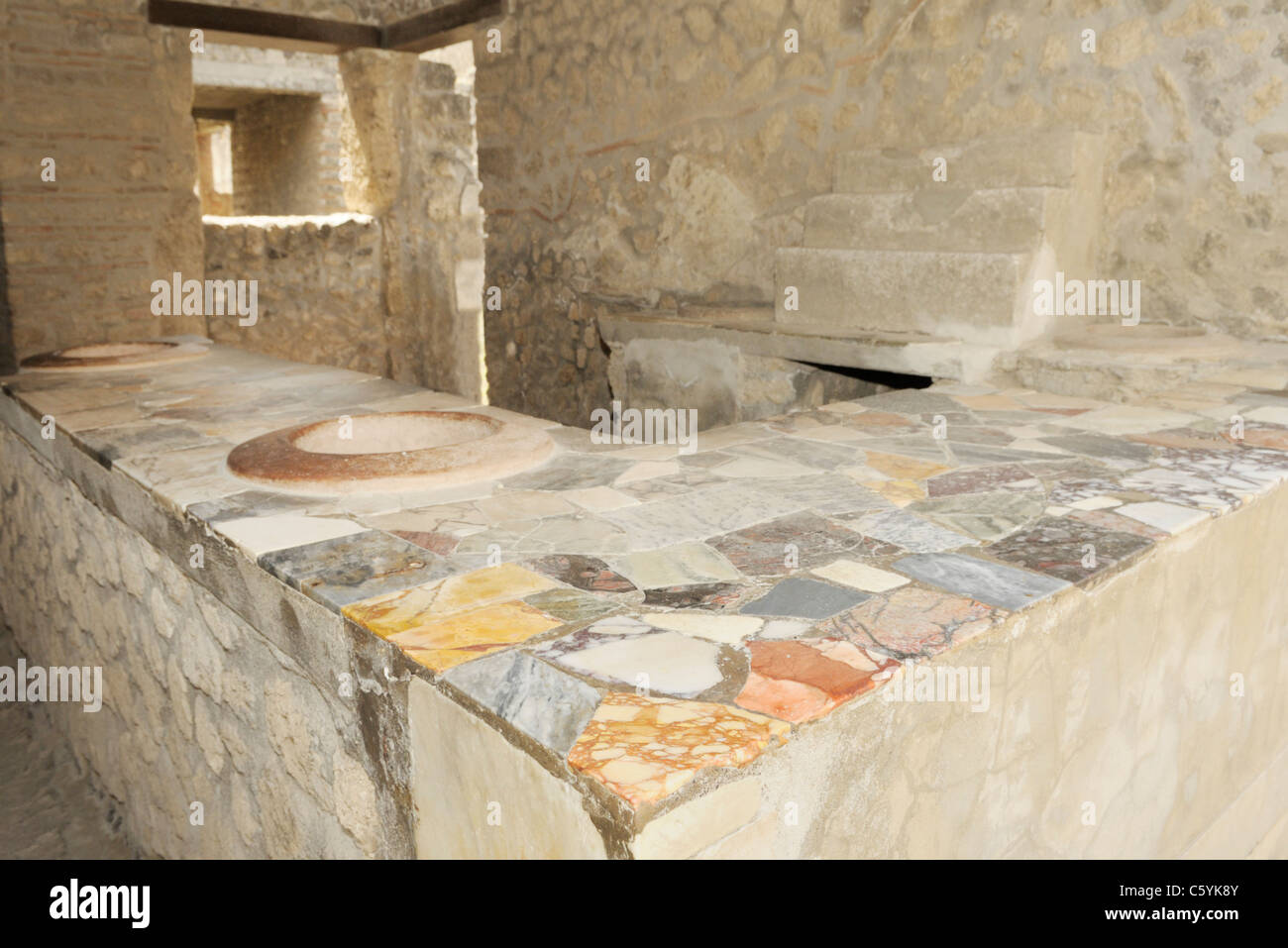 Thermopolium (snack-bar - boutique pour acheter le déjeuner), avec plateau en marbre de couleur, Pompéi. Il y avait 89 thermopolia à Pompéi. Banque D'Images