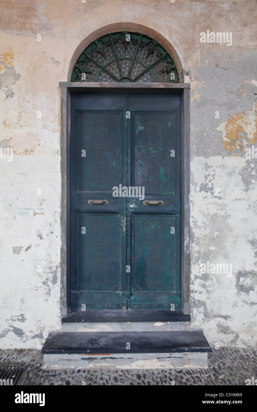 Une vieille porte verte et avec un vieux mur avec des couches de peinture pèle du Banque D'Images