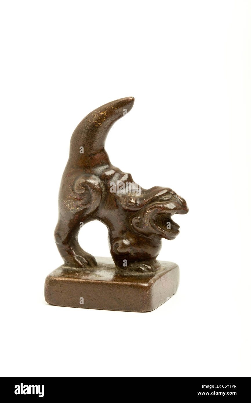 Petit poids couleur bronze antique dans la forme d'un monstre mythique, probablement un poids de défilement. Banque D'Images