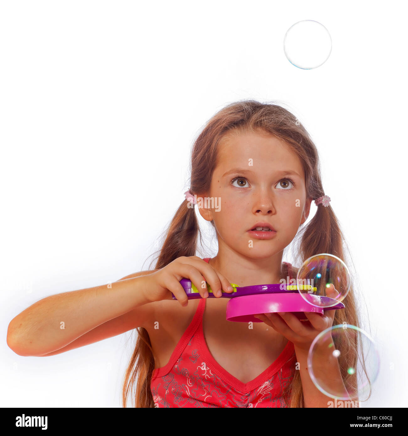 Fillette de huit ans jouer avec des bulles de savon Banque D'Images