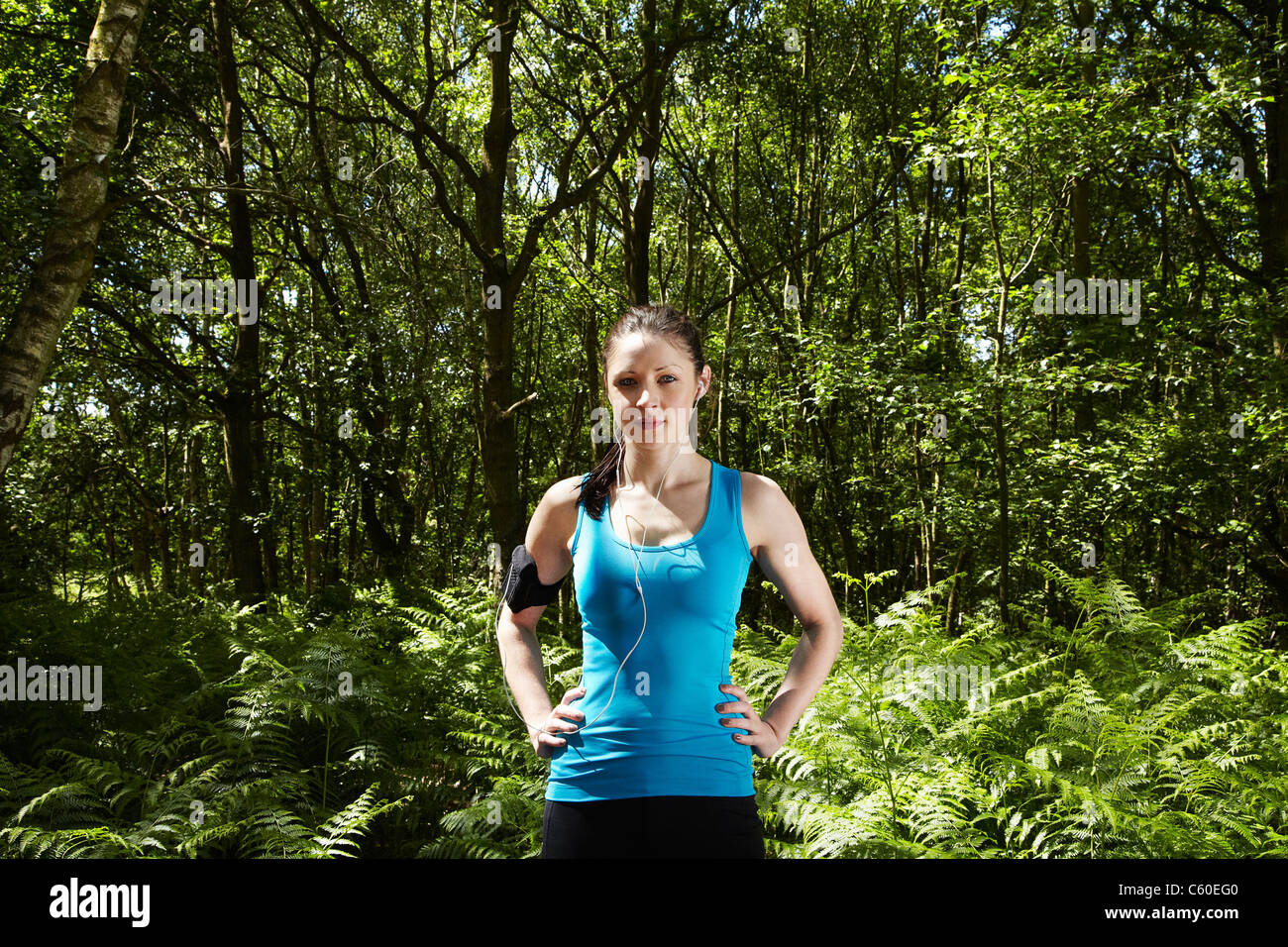 Runner standing in forest Banque D'Images