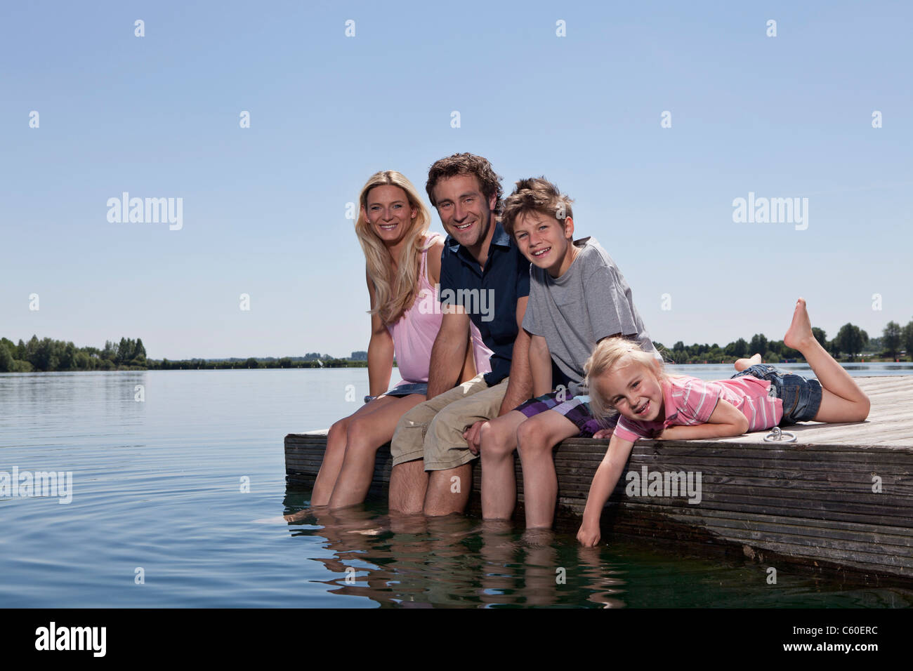 Family relaxing together on dock Banque D'Images