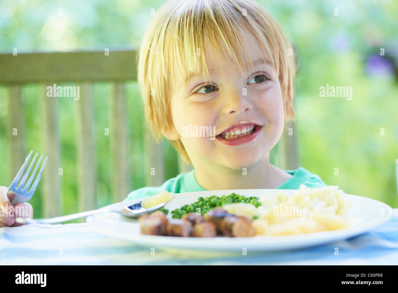 Smiling boy eating assiette de nourriture Banque D'Images