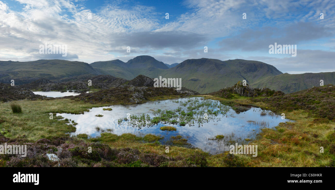 Tarn innommé sur meules de foin avec grand Gable (centre) et Kirk est tombé (à droite) dans la distance. Lake District. La région de Cumbria. UK. Banque D'Images