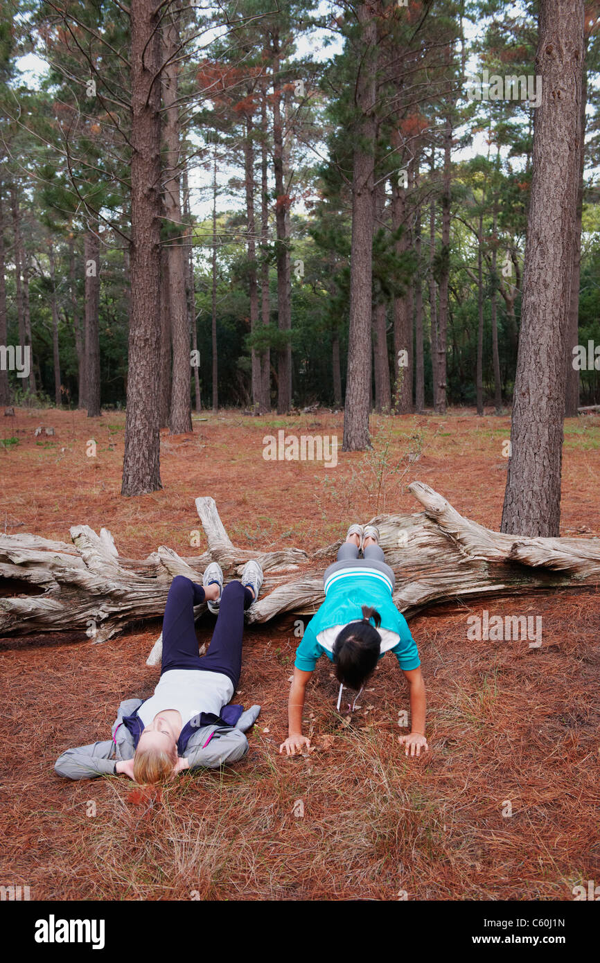 Les femmes exerçant ensemble en forêt Banque D'Images