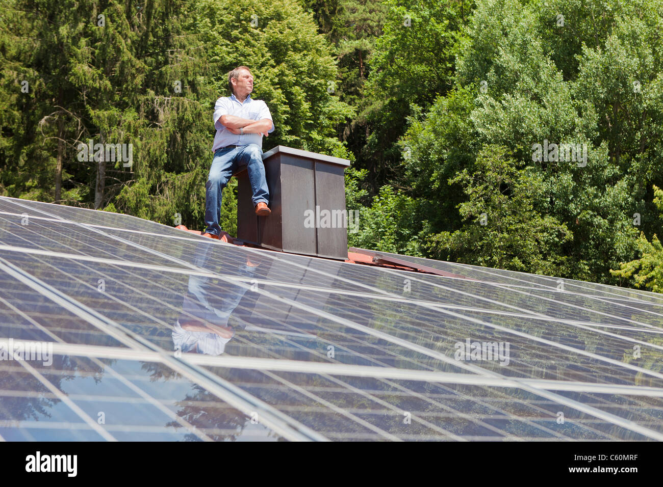 Homme debout sur le toit de panneaux solaires Banque D'Images