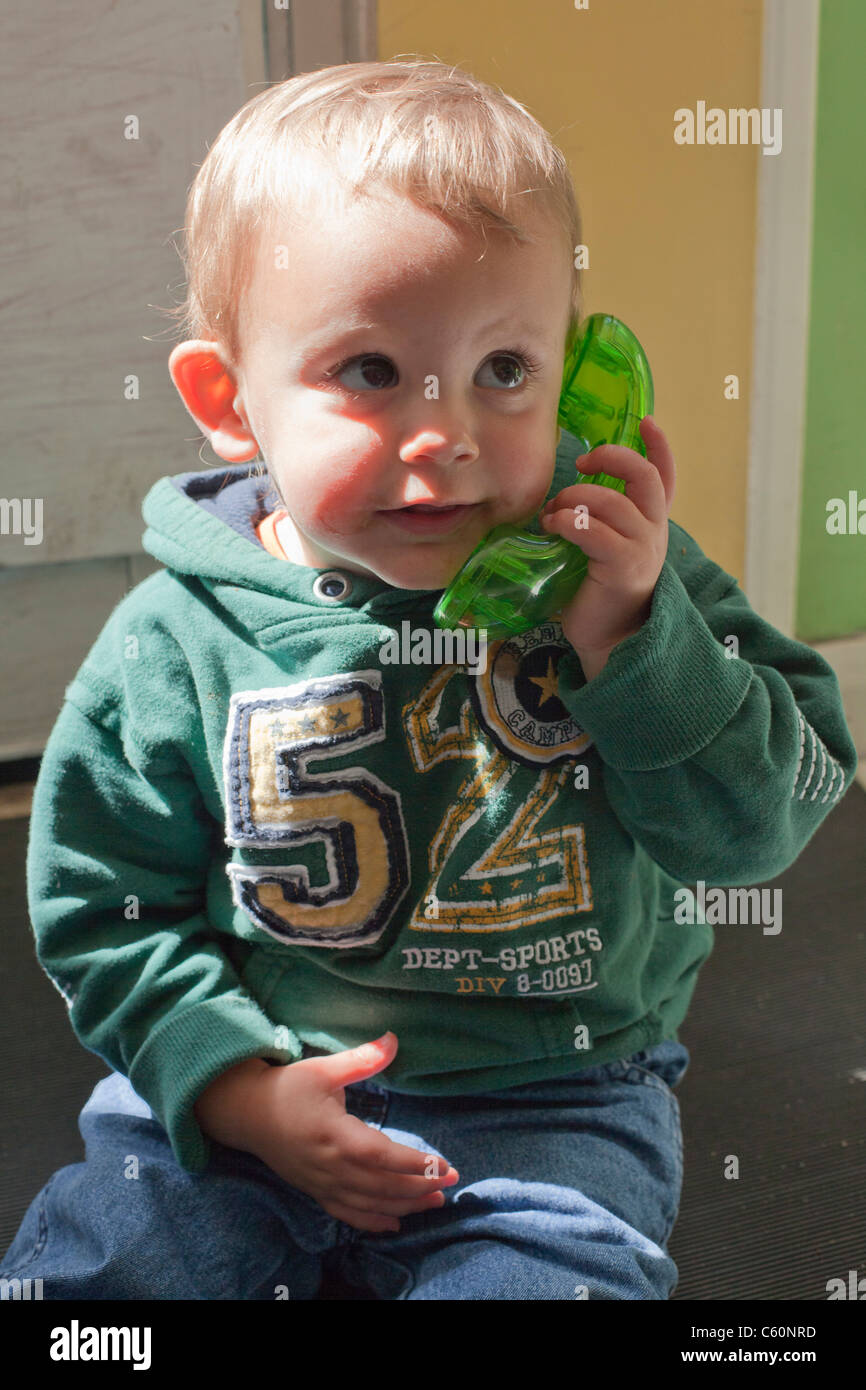 Baby boy playing with toy téléphone Banque D'Images
