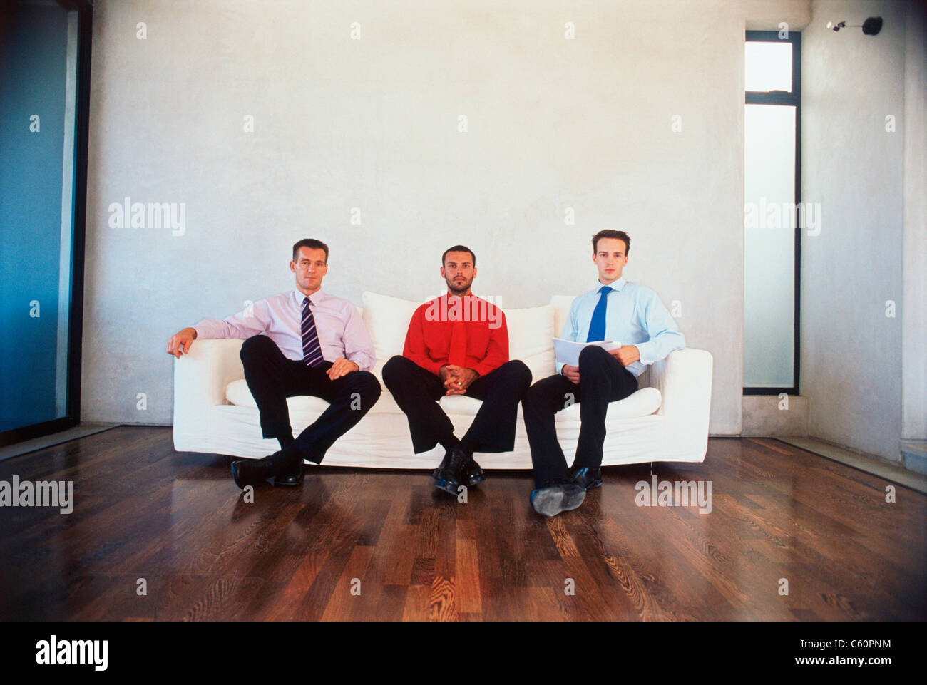 Hommes d'sitting on couch in office Banque D'Images
