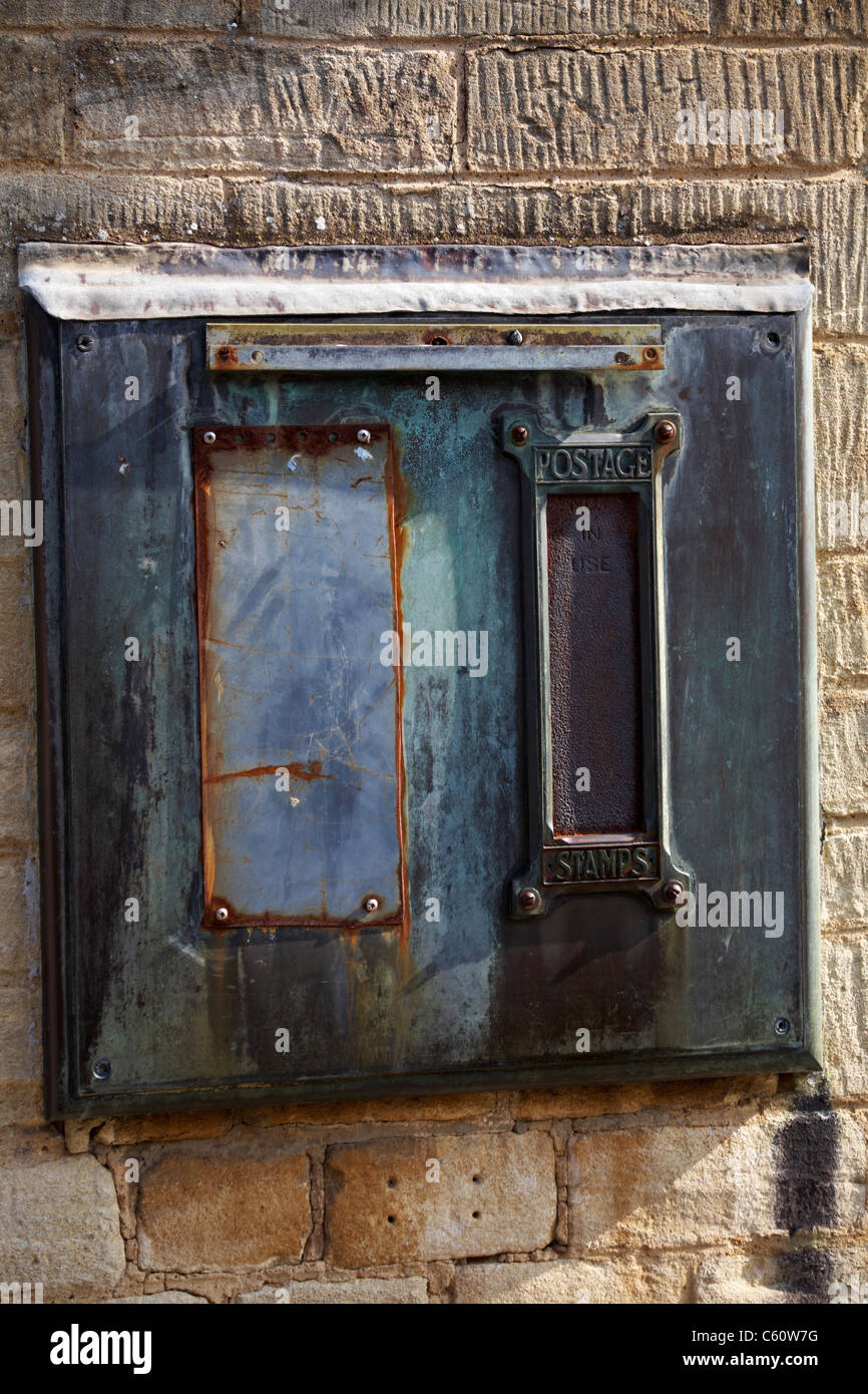 Ancienne machine à timbres-poste sur le côté du mur du bureau de poste à Moreton, dans Marsh, dans les Cotswolds, au Royaume-Uni, en juillet Banque D'Images