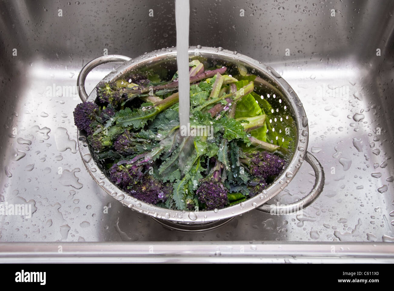 Laver les légumes dans une passoire en acier inoxydable Photo Stock - Alamy