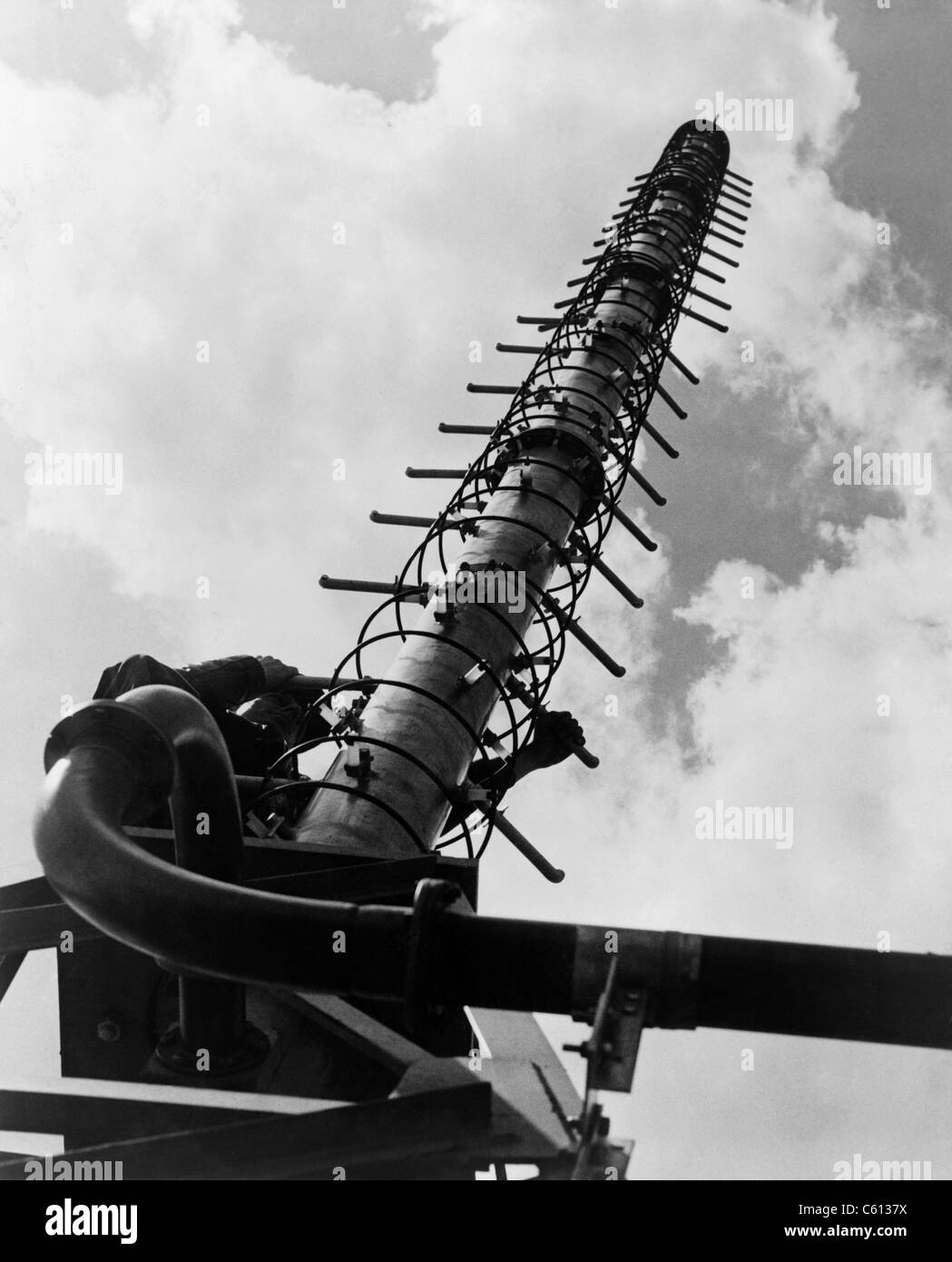 Worker climbing une antenne de télévision hélicoïdal développé par les ingénieurs de General Electric en 1951. Antennes hélice se composent d'un fil conducteur enroulé sous la forme d'une hélice, et étaient plus petits et plus portable que les antennes de radiodiffusion. Banque D'Images