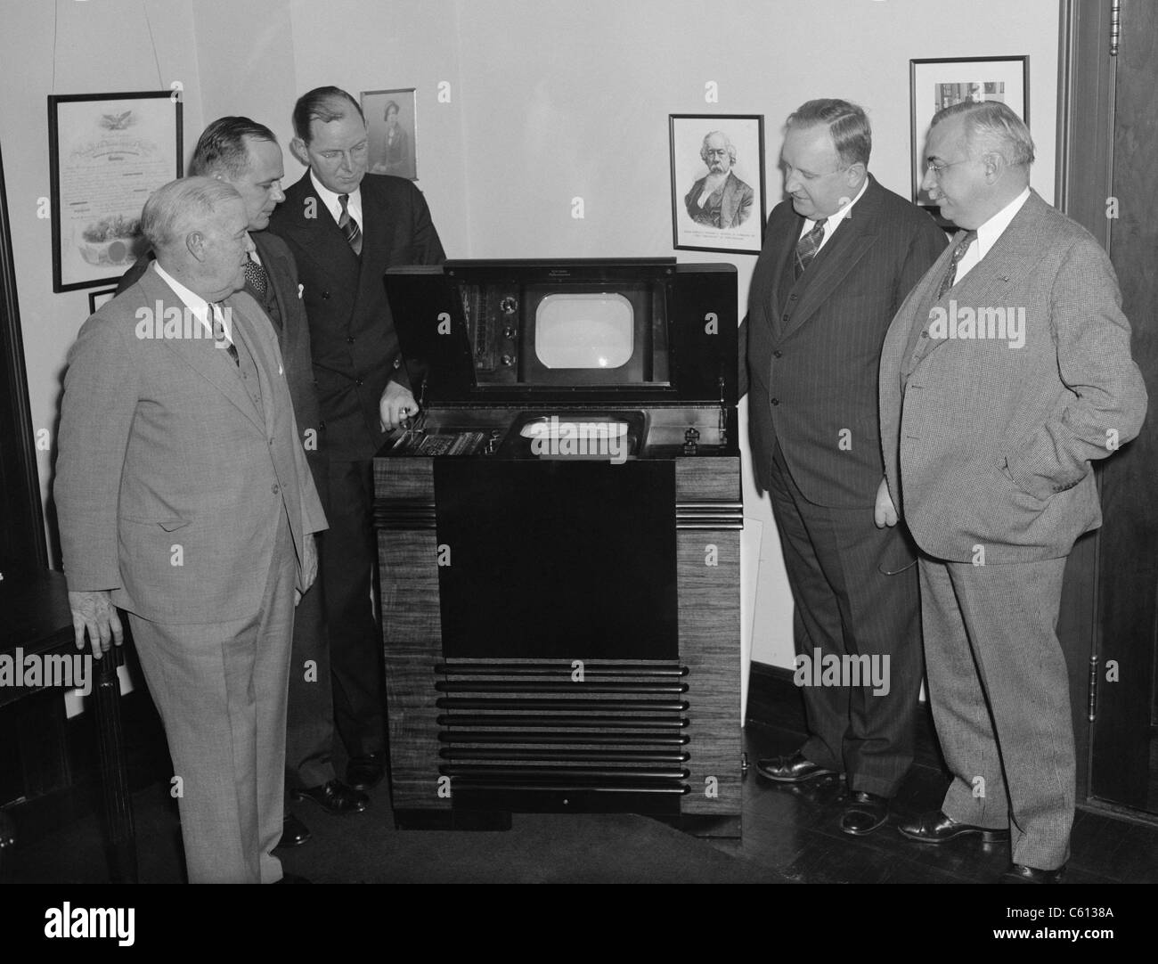 Les commissaires de la FCC inspecter dernière télévision dans 1939. La télévision avait un petit écran incased horizontalement dans une grande armoire en bois et a été vue d'un miroir réfléchissant. De gauche à droite : Les commissaires Frederick I. Thompson, T.A.M. Craven, président James L. Fly, Commissaires Thad H. Brown, et Norman S. CAS. Banque D'Images