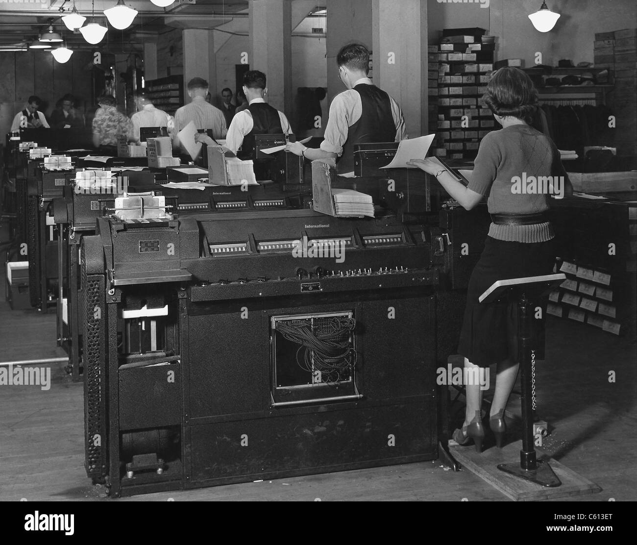 Les commis de l'Administration de la sécurité sociale assis à la compilation massive des machines, au début en fait, les ordinateurs utilisés pour gérer les dossiers individuels de millions d'Américains dans le système de sécurité sociale. Ca. 1940. Banque D'Images