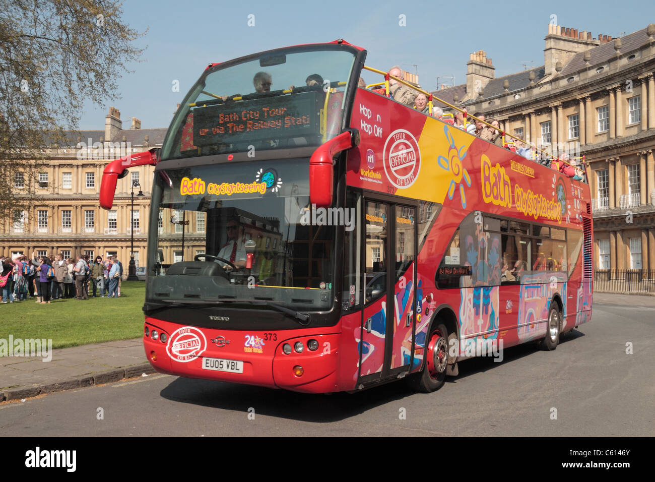 Une baignoire bus touristiques des environs de la conduite des propriétés sur le Circus à Bath, Somerset, Angleterre. Banque D'Images