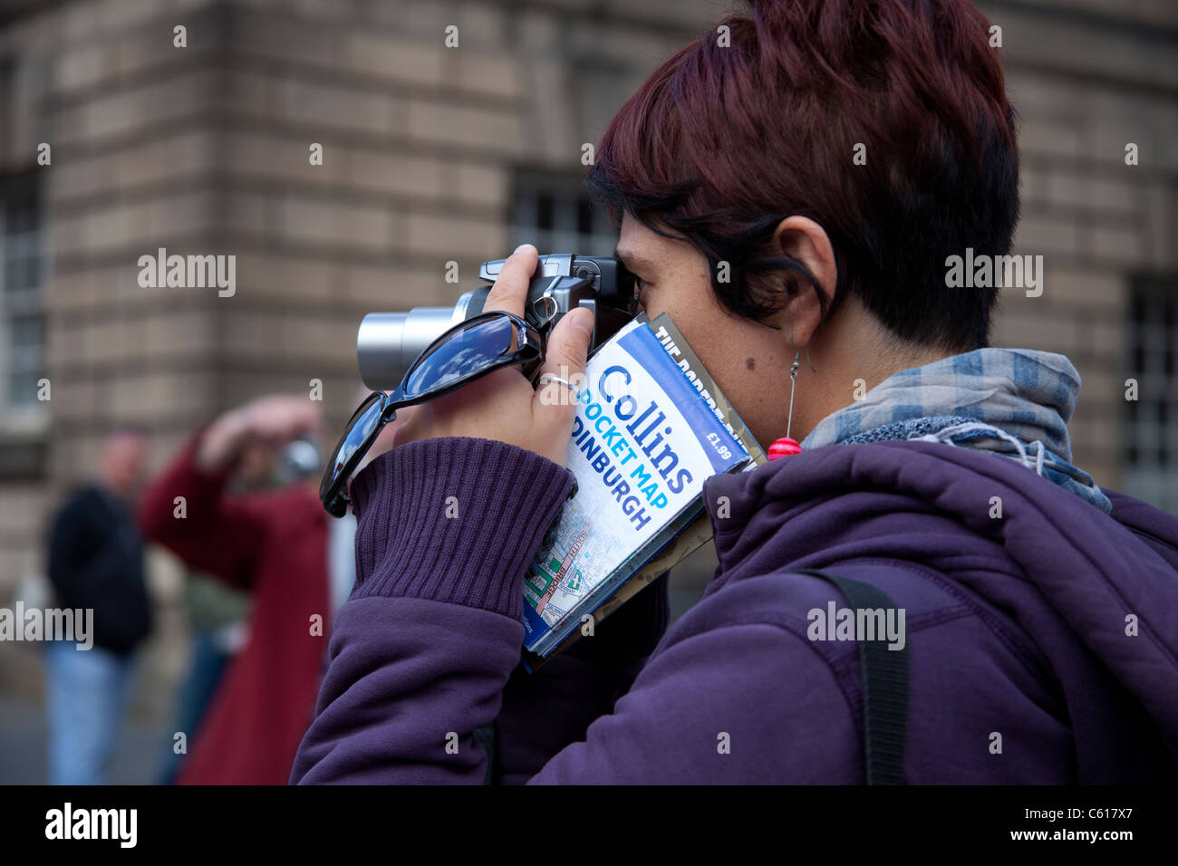 Woman taking photograph guide Édimbourg avec appareil photo avec l'Écosse Angleterre Europe Banque D'Images