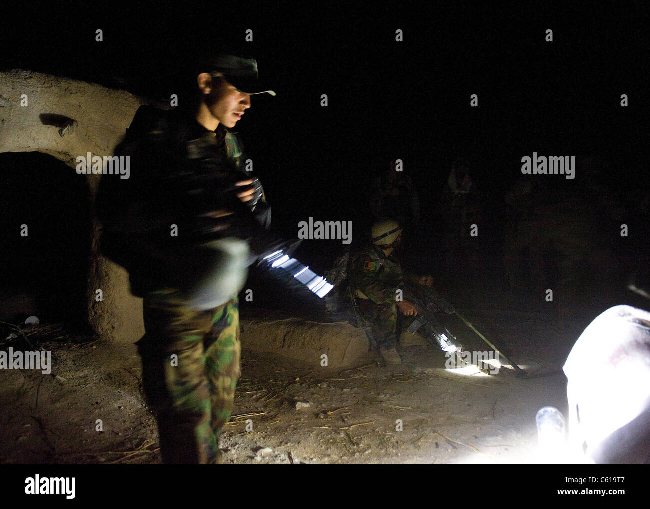 Un commandant de l'armée nationale afghane, assisté des forces spéciales de l'armée américaine et des phoques de la marine de la Force opérationnelle des opérations spéciales Sud, inspecte visuellement une moto pendant les premières heures du matin d'une opération de défrichement dans le district de Khakrez, province de Kandahar, Afghanistan, le 31 mai 2011. L'opération a abouti à la suppression de quatre insurgés présumés, ainsi qu'à l'exploitation de matériaux de fabrication d'IED et d'un dispositif d'observation d'armes. Le commando est avec le 3e Commando Kandak de l'Armée nationale afghane. (ÉTATS-UNIS Photo de l'armée par le Sgt. Daniel P. Shook/libéré) Banque D'Images