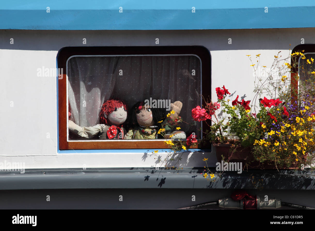 Poupées Rosie et Jim RAG, vue par une fenêtre de barge de canal, Royaume-Uni Banque D'Images