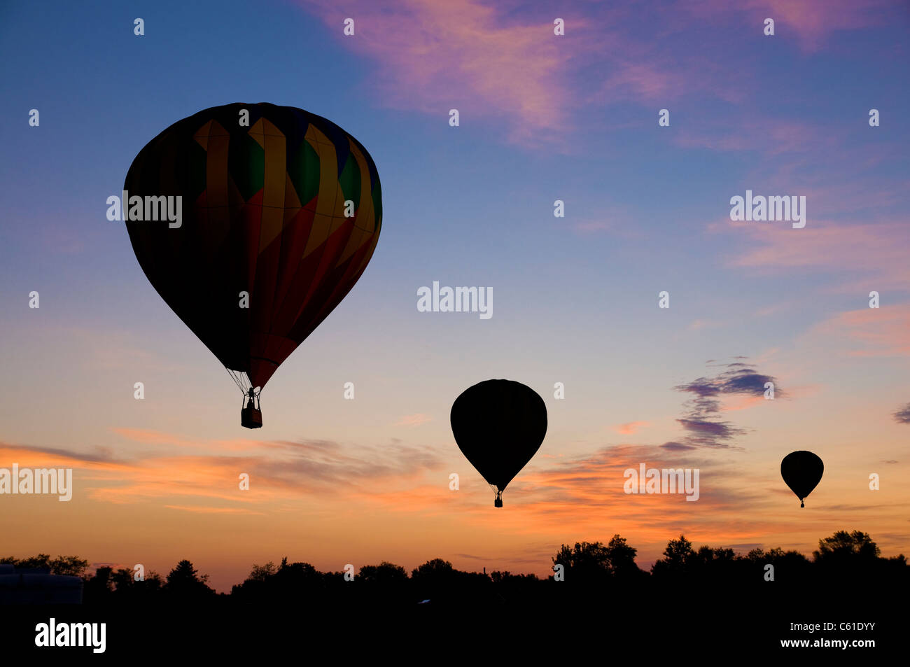 Les ballons à air chaud floating contre un ciel rougeâtre l'aube ou au crépuscule Banque D'Images