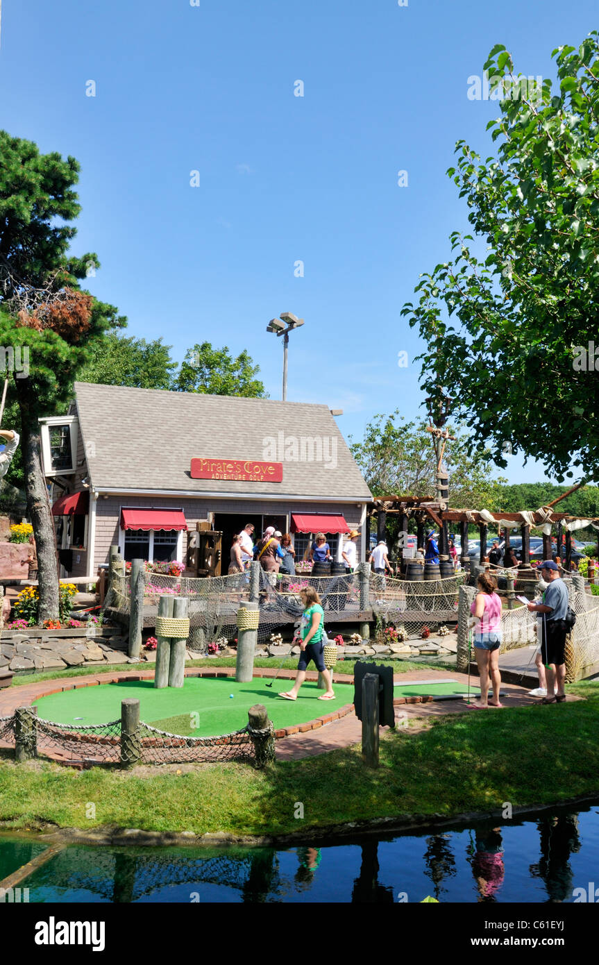 Les vacanciers jouant au mini-golf à Pirate's Cove, Yarmouth, Cape Cod sur un beau ciel bleu clair jour d'été ensoleillé. USA Banque D'Images