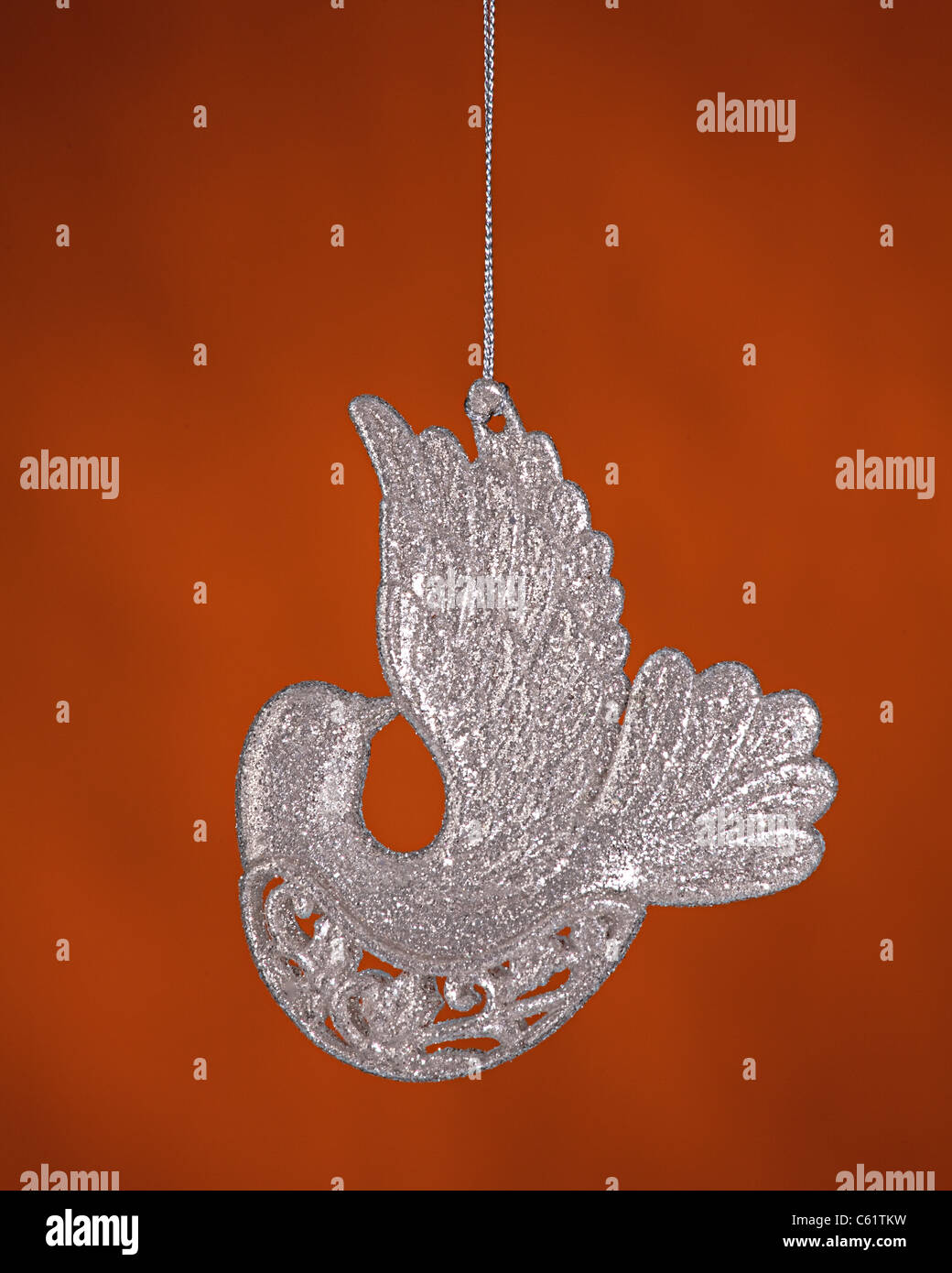 Un éclat argent colombe couleur d'ornement d'arbre de Noël des oiseaux isolés contre un fond d'or. Banque D'Images