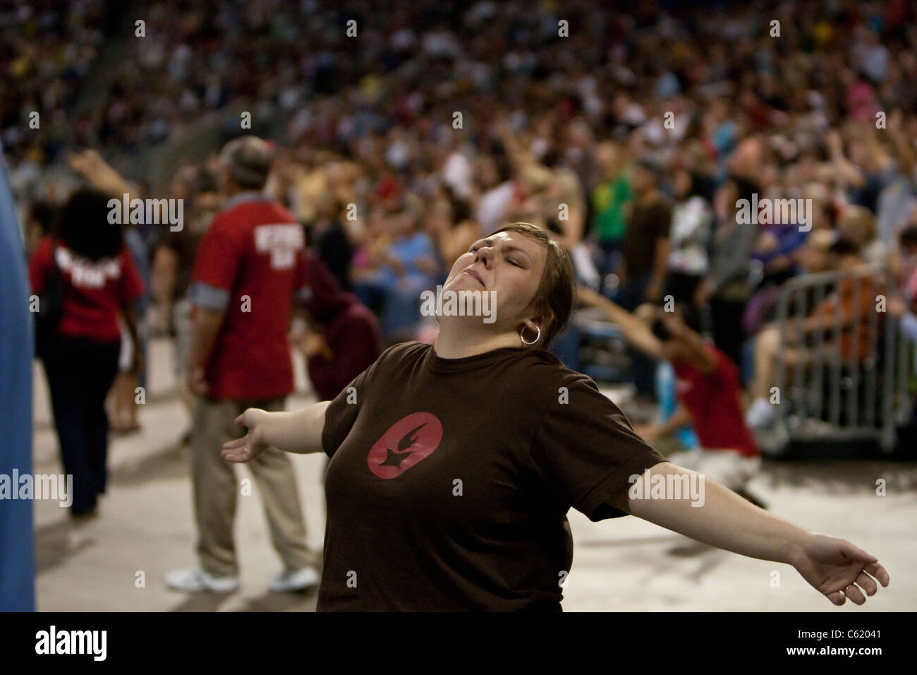 Femme blanche tendre les bras dans la prière pendant la journée événement chrétien à stade de Houston, Texas Banque D'Images