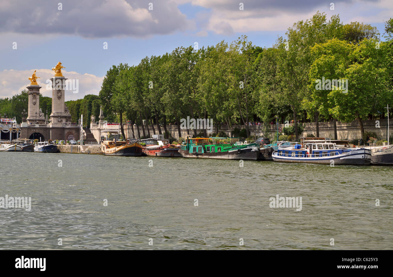 Péniches amarré à côté Pont Alexandre III sur la Seine, Paris, France. De nombreuses barges sont disponibles pour locations de vacances. Banque D'Images