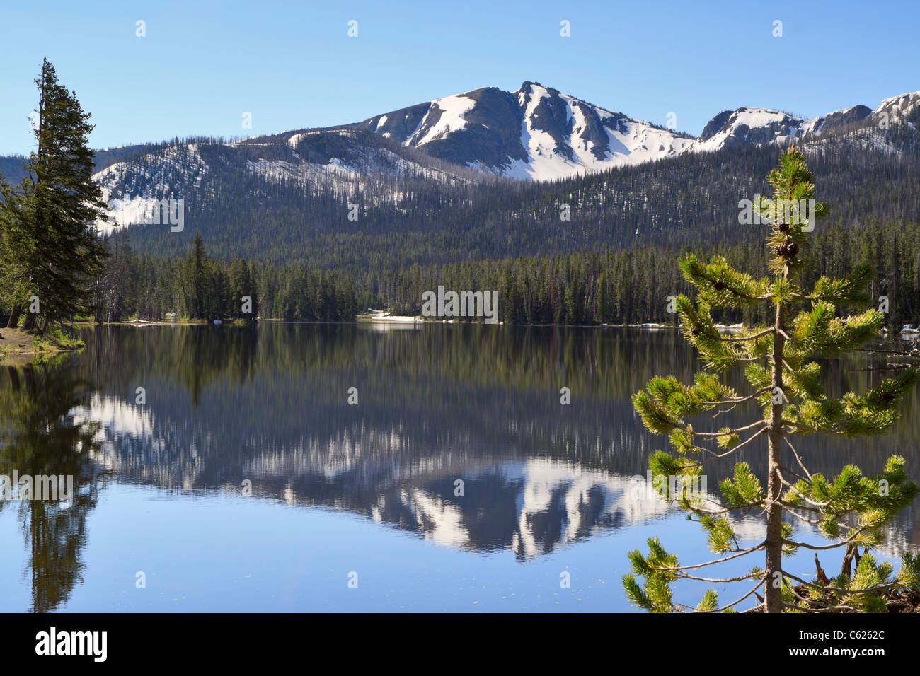 Sylvan Lake, le Parc National de Yellowstone, Wyoming. Montagnes couvertes de neige reflète dans l'eau encore près de Sylvan Pass. Banque D'Images