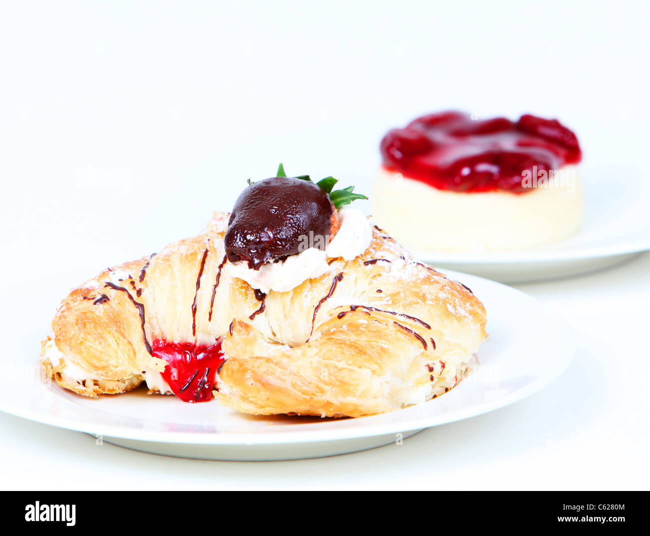 Rempli de crème croissant et gâteau au fromage aux fraises sur fond blanc Banque D'Images