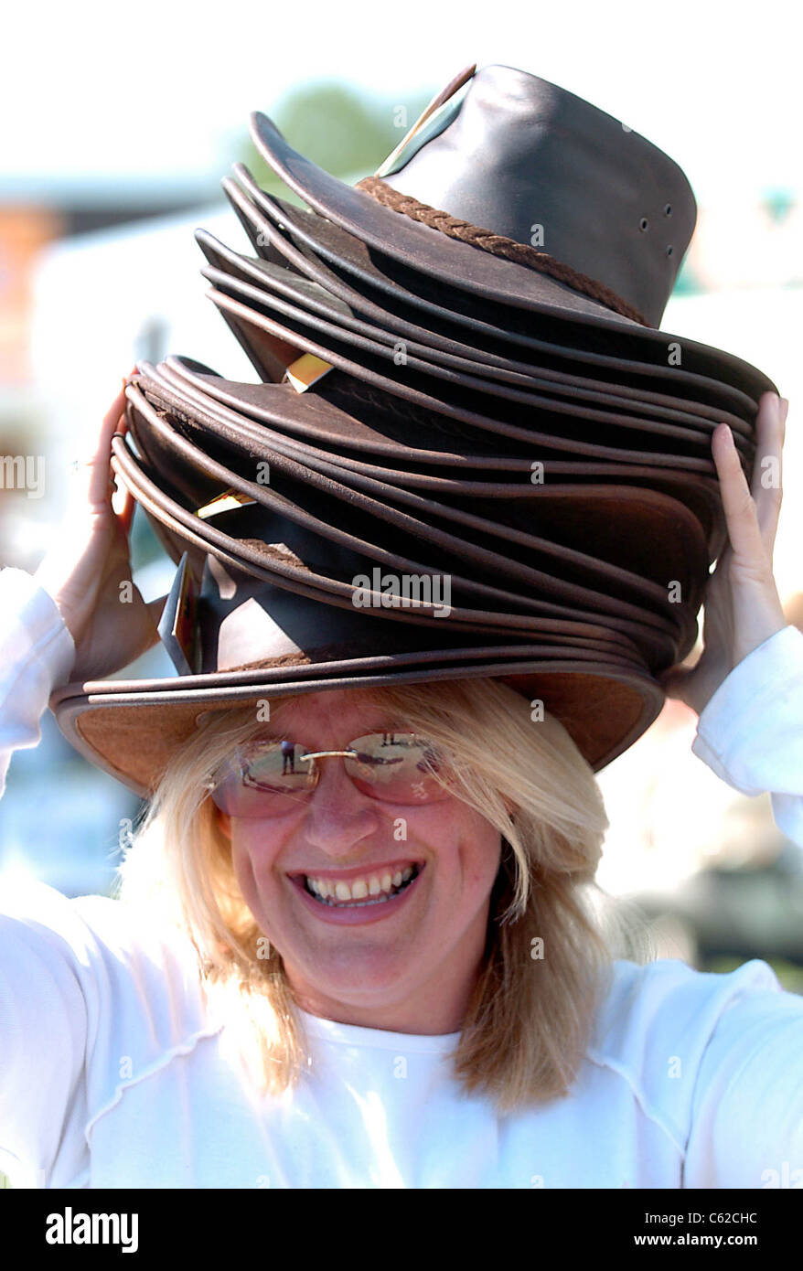 Amanda Pape reste à l'ombre sous une pile de chapeaux au South of England Show à Ardingly Sussex UK Banque D'Images
