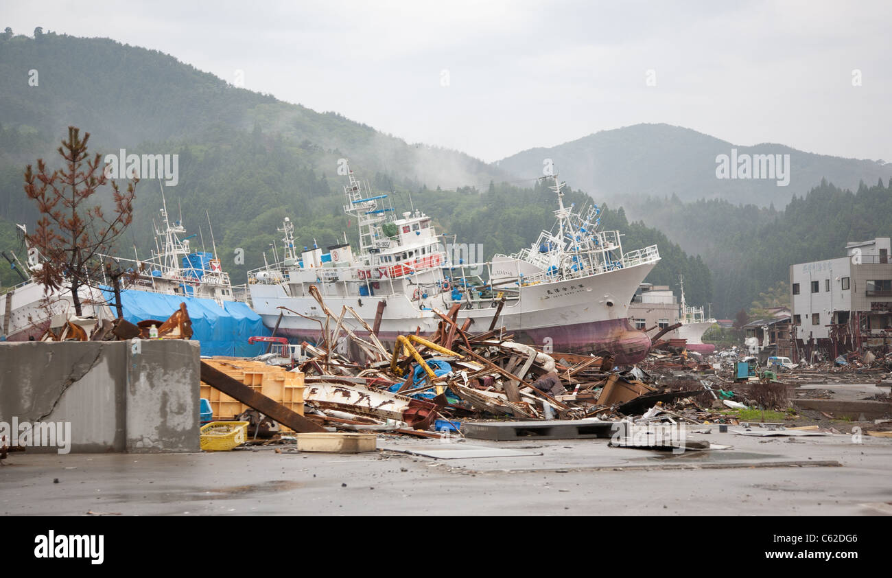 Les navires échoués dans l'arrière-plan tandis que des piles de débris jonchent le sol dans la région de Kesennuma, Japon, juin 2011 Banque D'Images