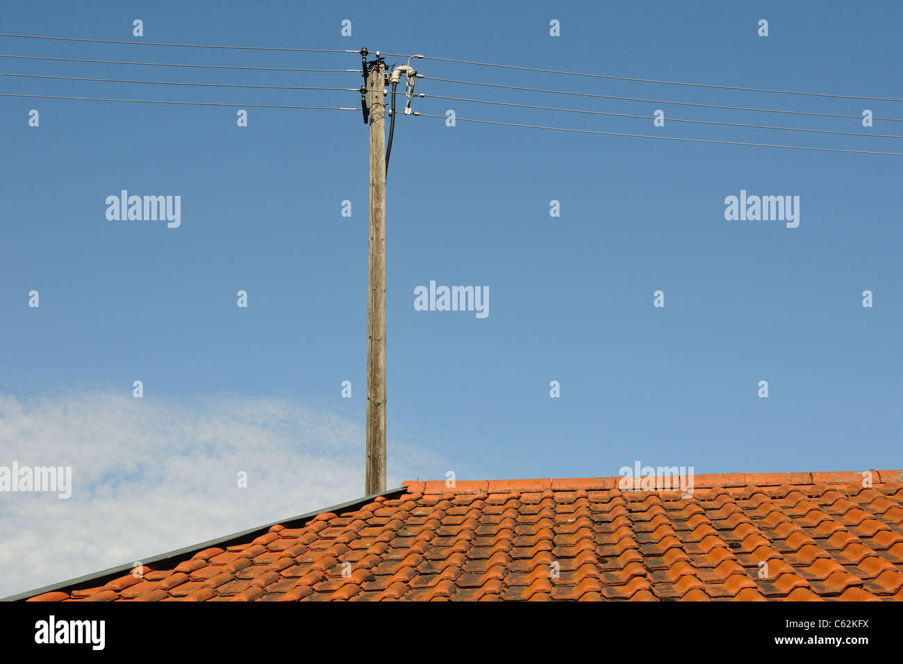 Style vieux toit en tuiles rouges avec du fil bleu ciel d'été post sur Banque D'Images