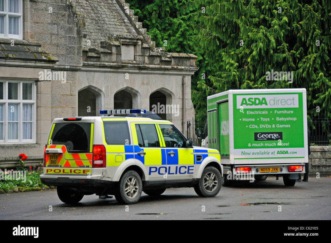Voiture de police et l'ASDA camion de livraison à l'entrée pour le château de Balmoral. Balmoral, Royal Deeside, Aberdeenshire, Ecosse, Royaume-Uni. Banque D'Images