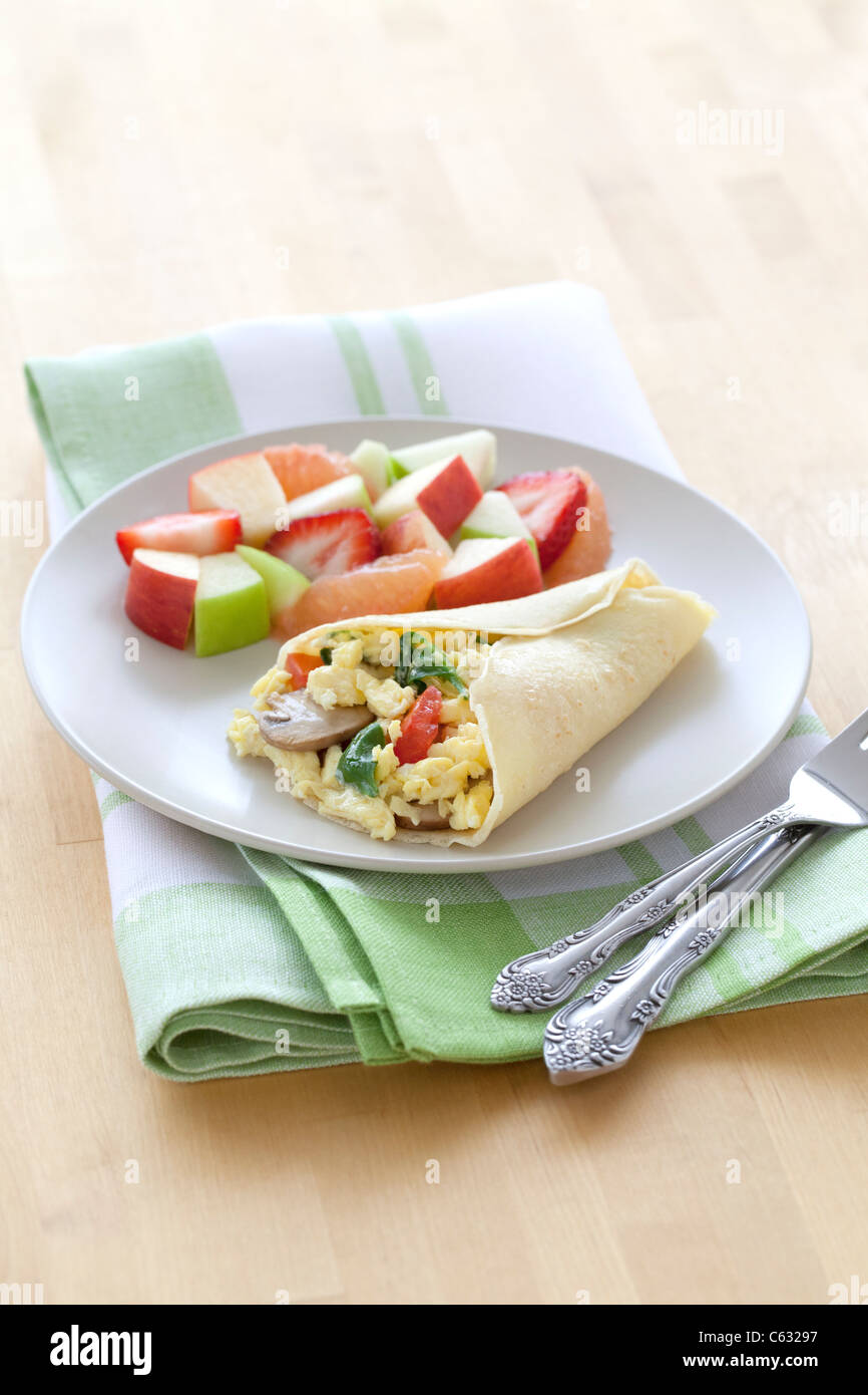 Un petit-déjeuner sain composé d'une crêpe et remplis d'oeufs fruits frais. Banque D'Images