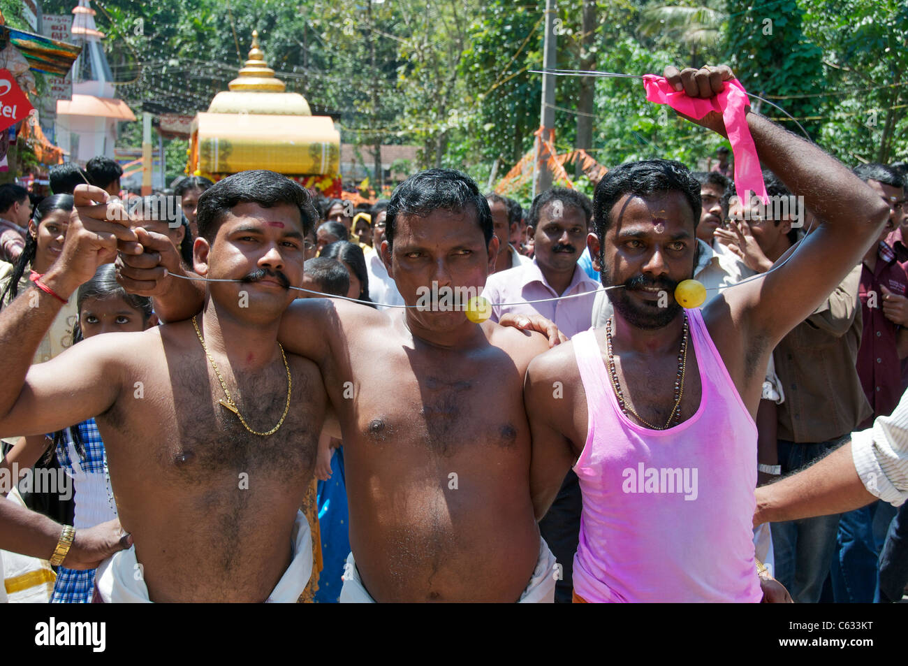 Trois hommes connecté avec fil percé à travers les joues fête hindoue Kanjirapally Kerala Inde Banque D'Images