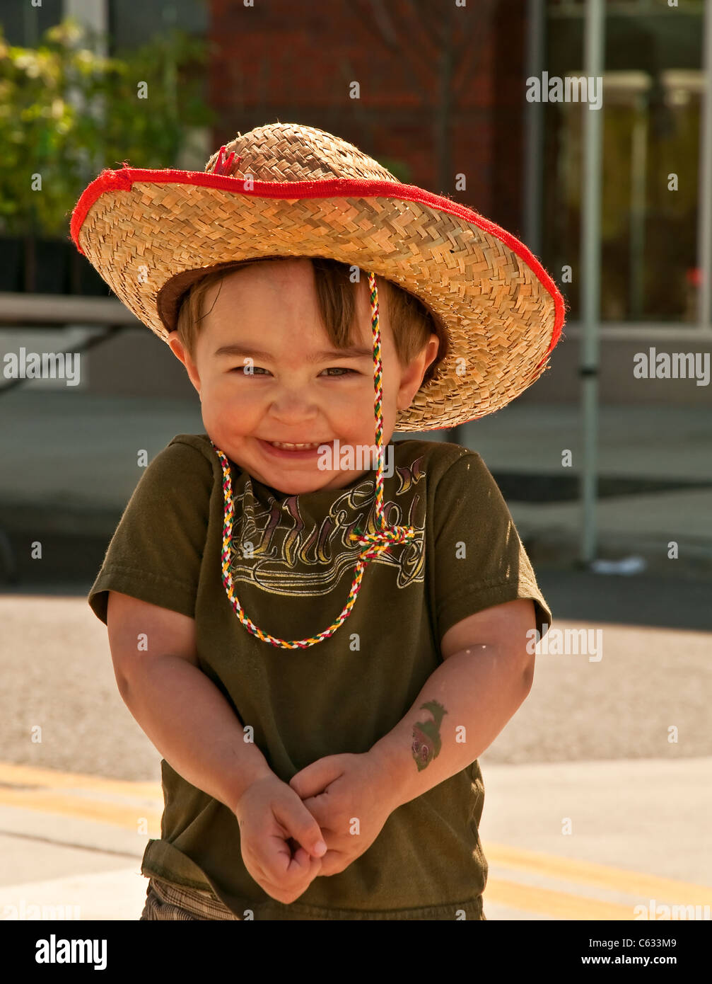 Cute, peu heureux 2 ans bébé garçon, souriant avec ses épaules haussa les  épaules. Il porte un chapeau de cow-boy de paille Photo Stock - Alamy