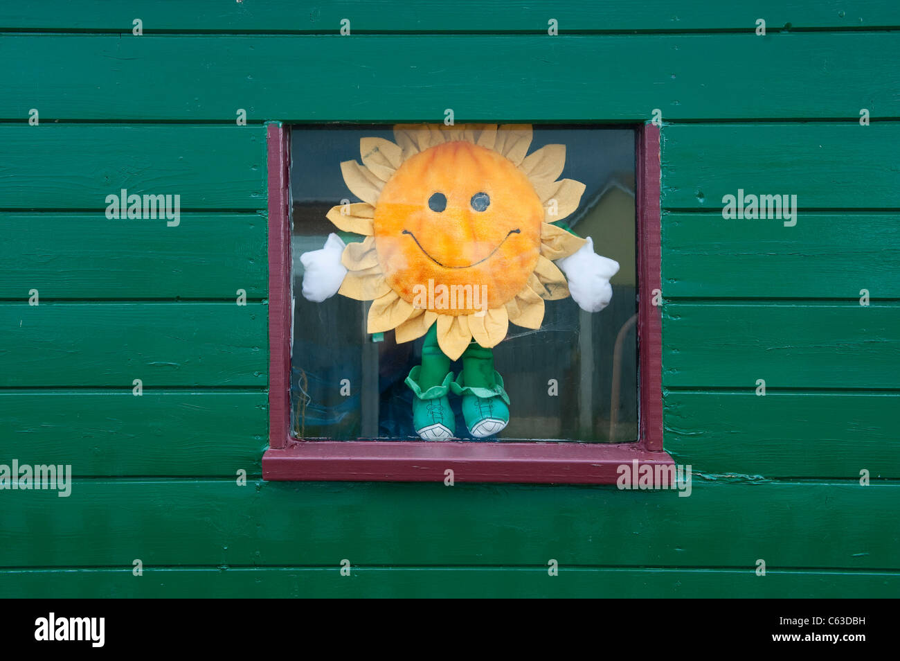 tournesol jouet artificiel dans la fenêtre de l'abri de jardin Banque D'Images