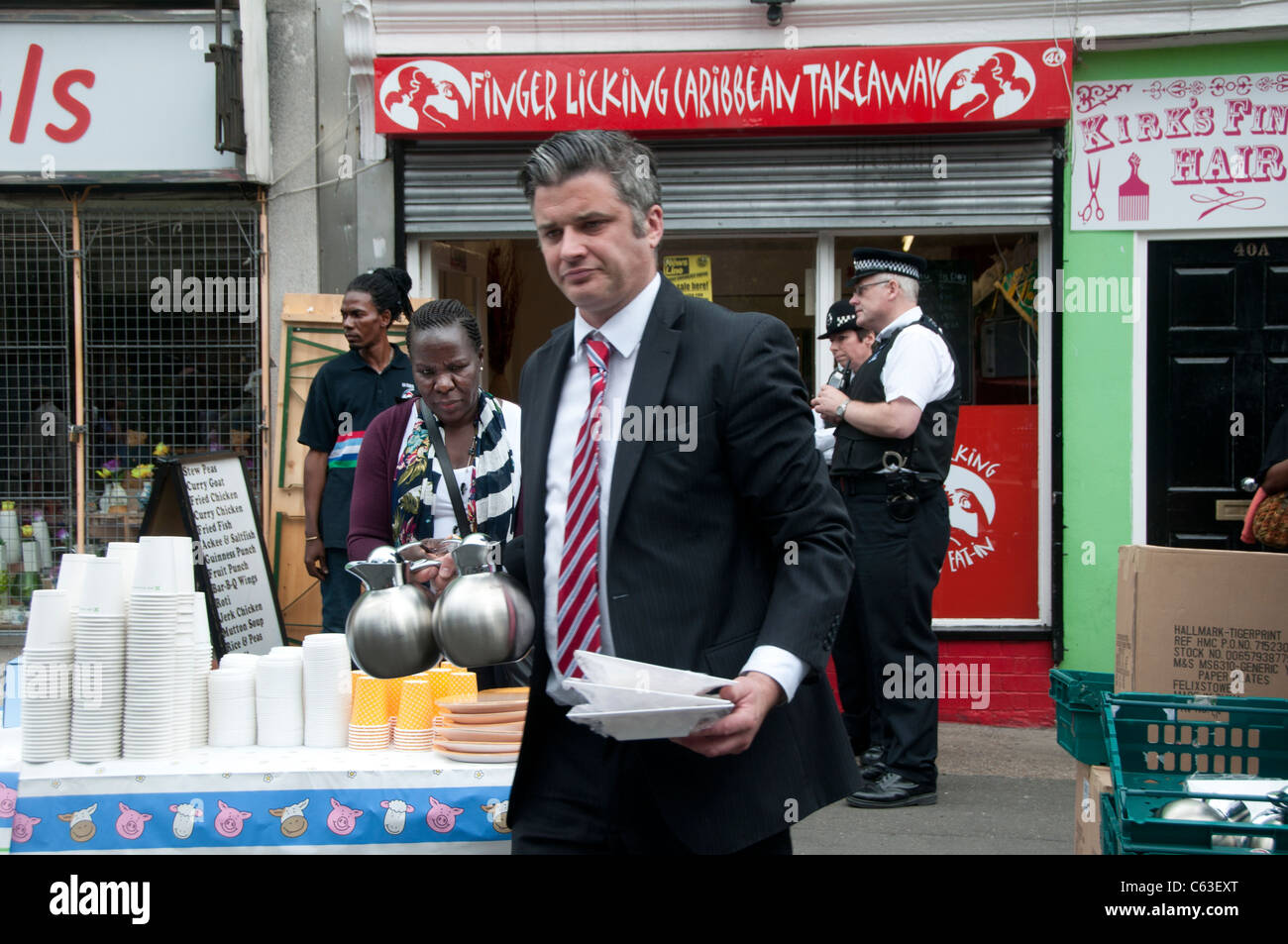 Clarence Road Hackney. Street tea party une semaine après les émeutes.Marks and Spencers manager avec des plaques et des théières Banque D'Images