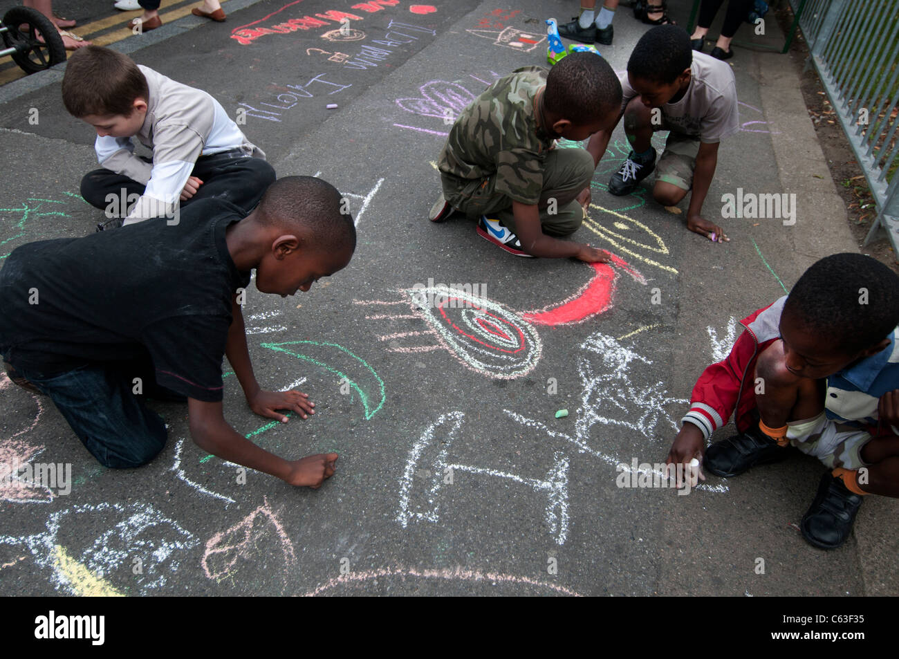 Clarence Road Hackney. Street tea party une semaine après les émeutes. Enfants dessinent à la craie sur le trottoir. Banque D'Images
