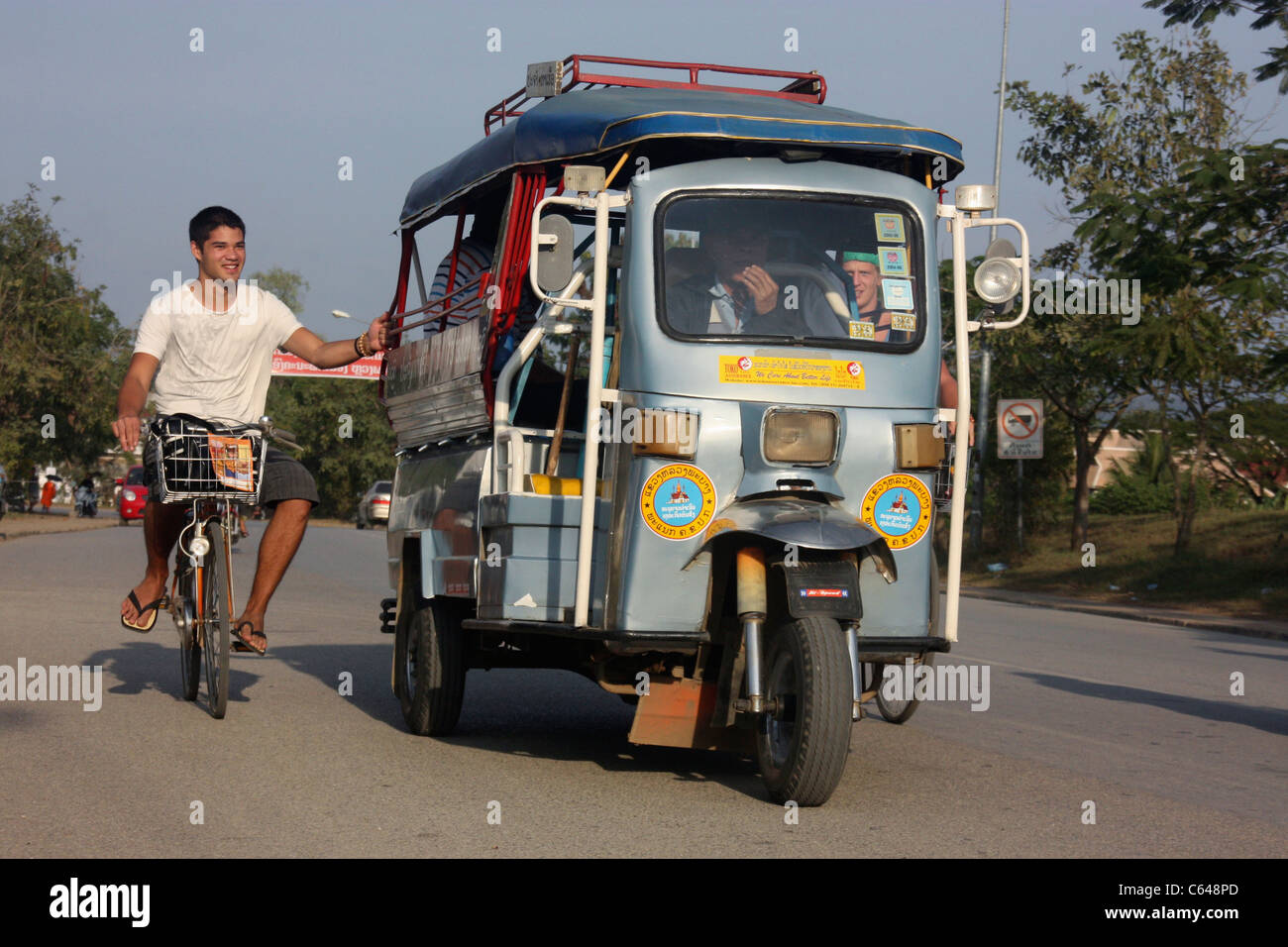 Les cyclistes dans un tour de pousse-pousse au passager tricycle laotienne Vientiane Laos Banque D'Images