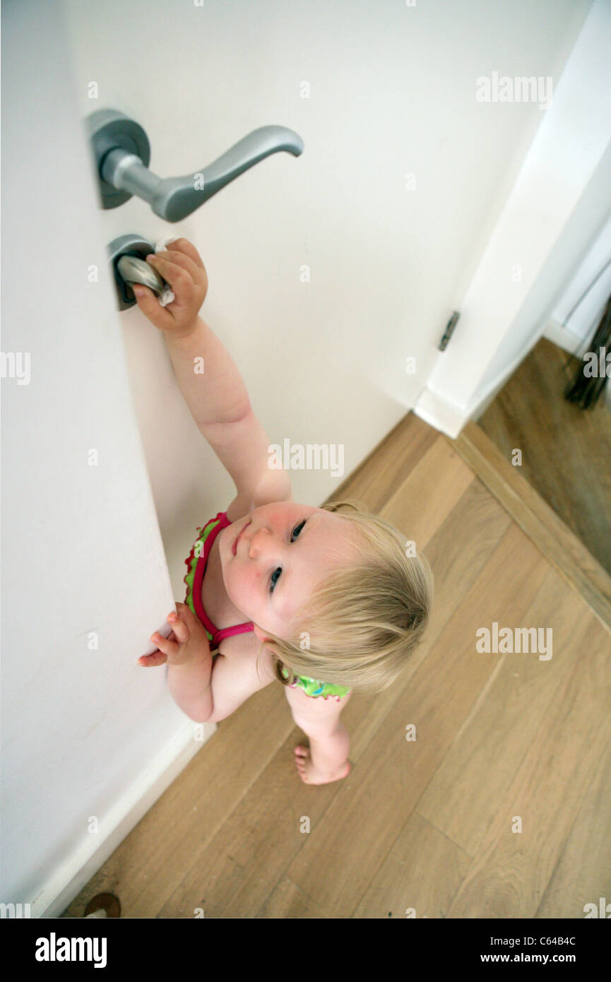 Un enfant essaie d'ouvrir la porte de la chambre. Banque D'Images